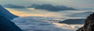 view from the top of a mountain looking above clouds and seeing other mountains in the distant
